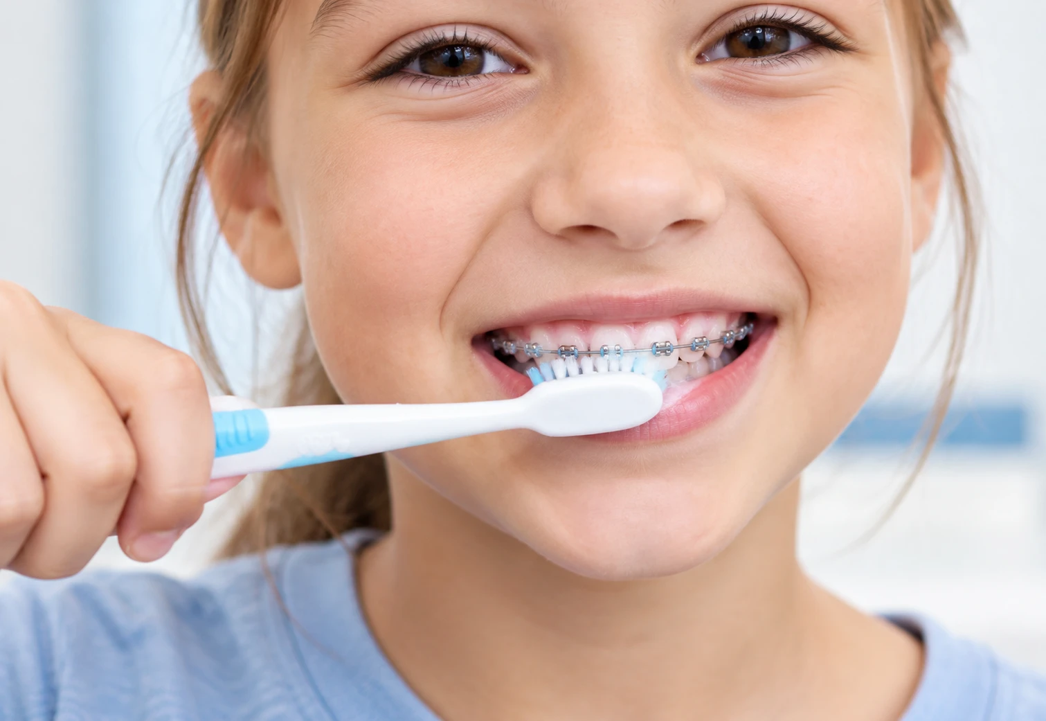 Child brushing teeth with braces