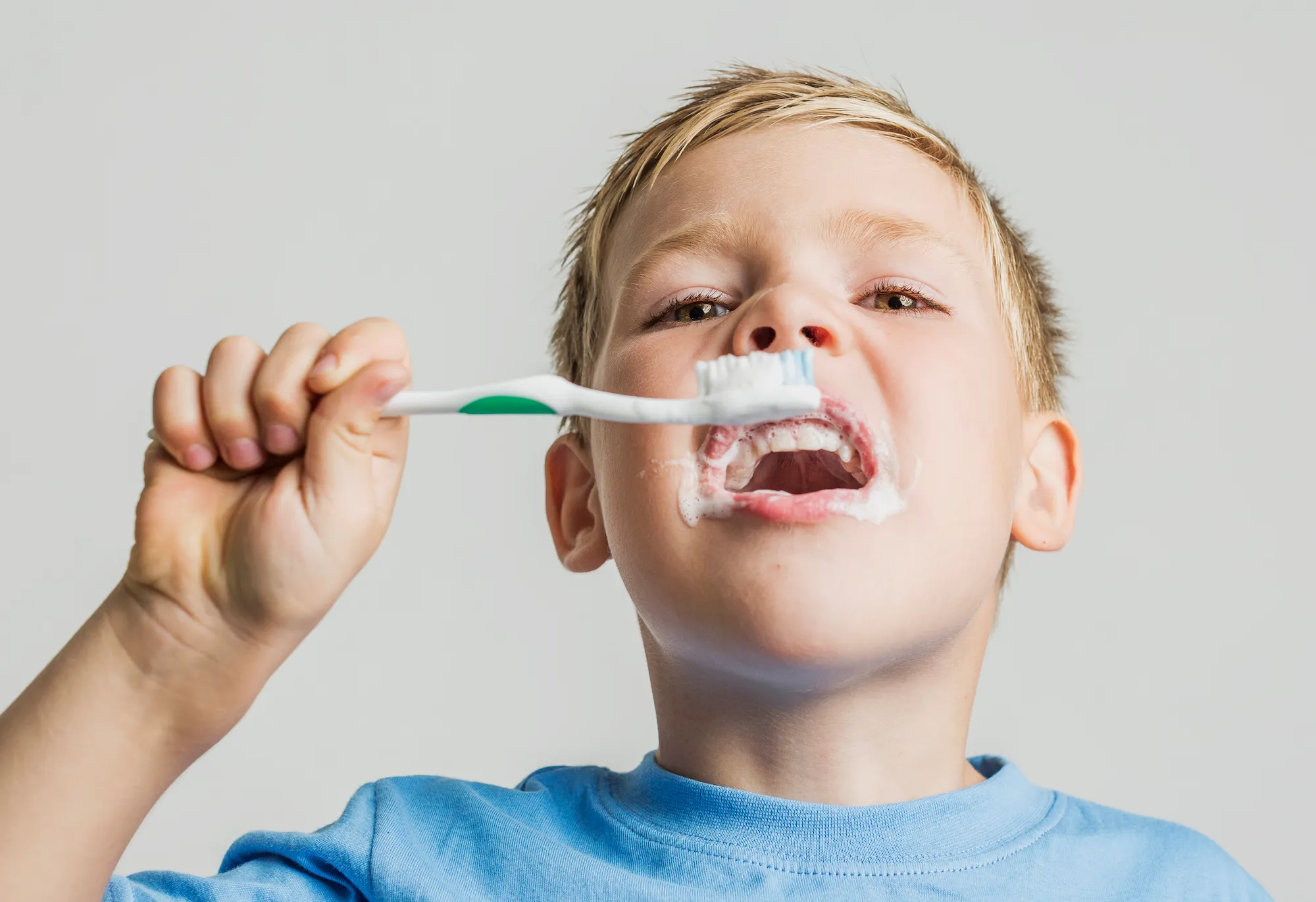 low-angle-kid-brushing-his-teeth